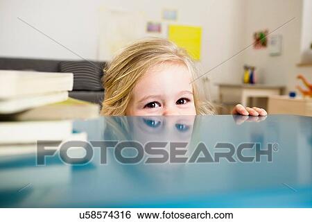 Girl peeking over table View Large Photo Image Stock Photograph - Girl peeking over table. Fotosearch