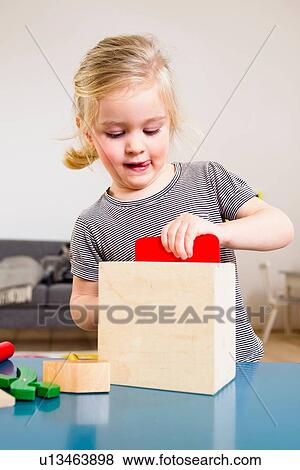 Stock Photo - Girl playing with building blocks at home. Fotosearch