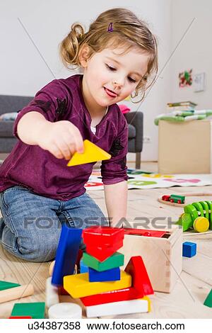 Girl playing with building blocks at home View Large Photo Image Stock Photo - Girl playing with building blocks at home. Fotosearch