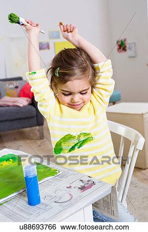 Stock Photograph - Girl playing with paint at home. Fotosearch