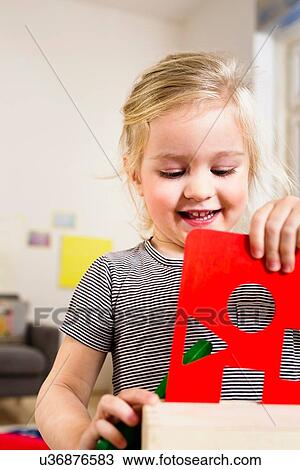 Stock Image - Girl playing with shape card. Fotosearch