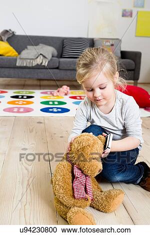 Girl playing with teddy bear at home View Large Photo Image Stock Image - Girl playing with teddy bear at home. Fotosearch