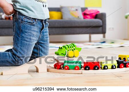 Picture - Girl playing with toy cars at home. Fotosearch
