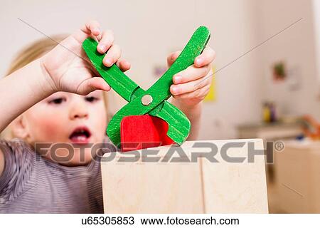 Girl playing with toy pliers View Large Photo Image Stock Image - Girl playing with toy pliers. Fotosearch