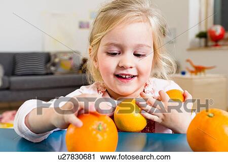 Girl taking oranges from table View Large Photo Image Stock Image - Girl taking oranges from table. Fotosearch