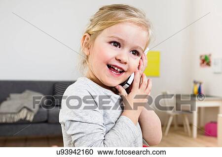 Girl talking on smartphone at home View Large Photo Image Stock Image - Girl talking on smartphone at home. Fotosearch