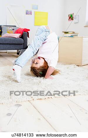 Girl trying to do headstand at home View Large Photo Image Stock Image - Girl trying to do headstand at home. Fotosearch
