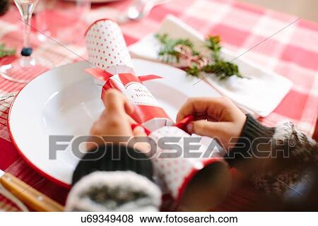Stock Photo - Girl with Christmas cracker at family Christmas party. Fotosearch