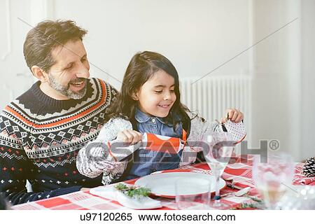 Stock Photography - Girl with Christmas cracker at family Christmas party. Fotosearch