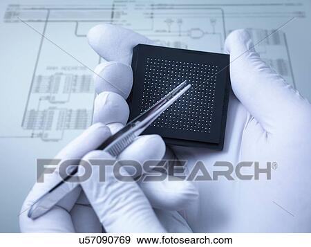 Stock Photo - "Gloved hands holding small electronic chips in laboratory, close up". Fotosearch