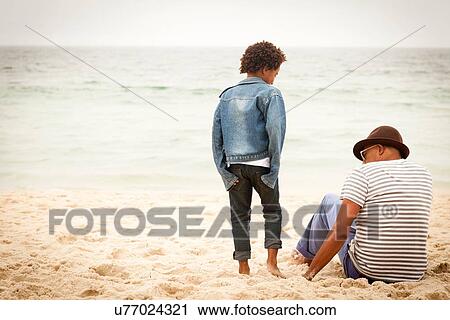 Stock Image - Grandfather and grandson on beach. Fotosearch