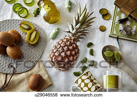Stock Photo - Green colored still life with pineapple and kiwi fruit. Fotosearch