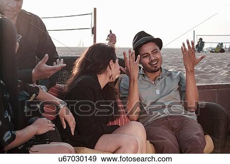 Group of friends at the beach talking and making hand gestures View Large Photo Image Stock Photo - Group of friends at the beach talking and making hand gestures. Fotosearch