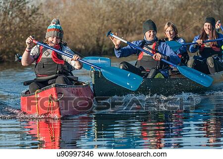 Stock Photograph - Group of people canoeing on river. Fotosearch