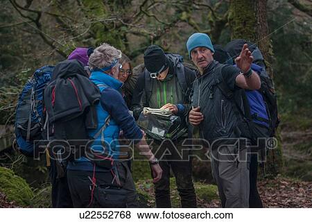 Stock Photo - Group of people in forest with map. Fotosearch