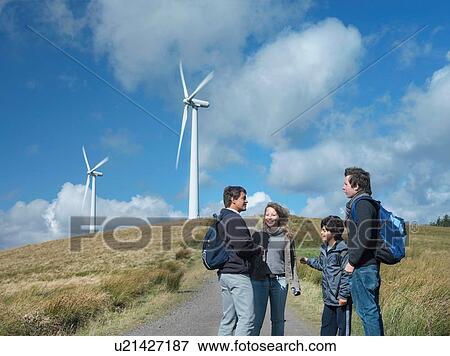 Stock Photo - Group of walkers on path at windfarm. Fotosearch