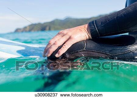Stock Photo - "Hands of surfer in the water, Bay of Islands, NZ". Fotosearch
