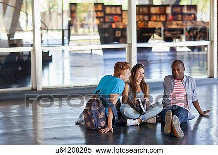 Stock Photography - Higher education students sitting on floor. Fotosearch