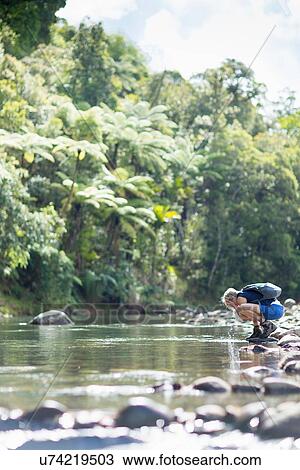 "Hiker walking among stones in shallow stream, Waima Forest, North Island, NZ" View Large Photo Image Stock Image - "Hiker walking among stones in shallow stream, Waima Forest, North Island, NZ". Fotosearch