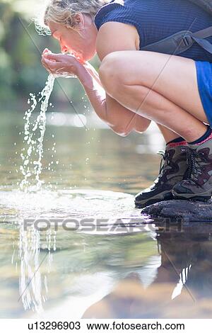 Hiker washing face with water from shallow stream View Large Photo Image Stock Image - Hiker washing face with water from shallow stream. Fotosearch