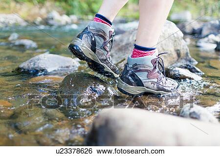 Hiker's feet walking on stones in shallow stream View Large Photo Image Stock Photograph - Hiker's feet walking on stones in shallow stream. Fotosearch