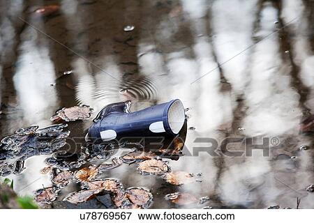 Stock Photo - Lone Wellington boot in water. Fotosearch