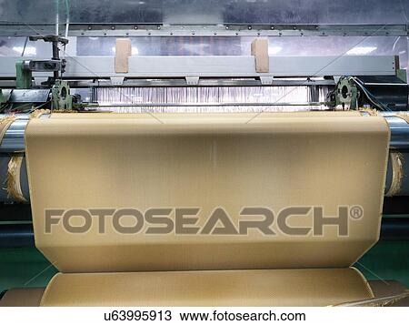 Stock Image - Loom weaving kevlar fabric in carbon fibre factory. Fotosearch