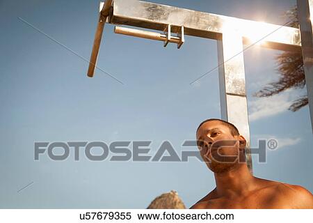 Stock Photography - Low angle portrait of mid adult man at outdoor gym. Fotosearch