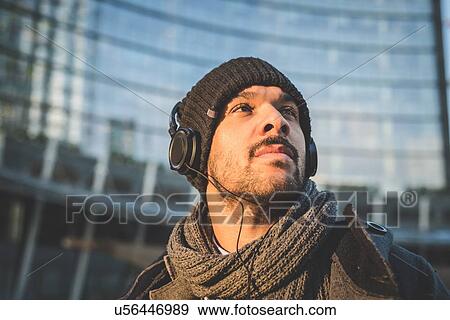 Stock Photo - Low angle view of businessman listening to headphones. Fotosearch