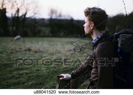Male hiker looking out over field View Large Photo Image Stock Image - Male hiker looking out over field. Fotosearch