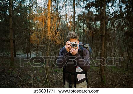 Male hiker photographing with digital camera in woods View Large Photo Image Stock Image - Male hiker photographing with digital camera in woods. Fotosearch