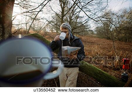 Male hiker taking a coffee break in woods View Large Photo Image Stock Image - Male hiker taking a coffee break in woods. Fotosearch