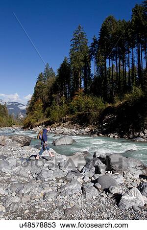 "Male hiker walking on river rocks, Grindelwald, Switzerland" View Large Photo Image Stock Image - "Male hiker walking on river rocks, Grindelwald, Switzerland". Fotosearch