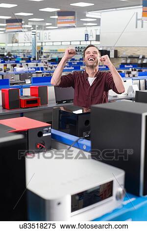 Male shopper celebrating finding product in electronics store View Large Photo Image Stock Photography - Male shopper celebrating finding product in electronics store. Fotosearch