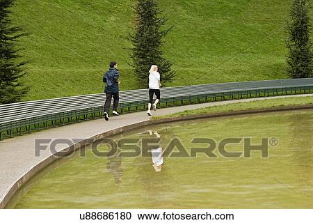 "Man and woman running beside lake, rear view" View Large Photo Image Stock Image - "Man and woman running beside lake, rear view". Fotosearch