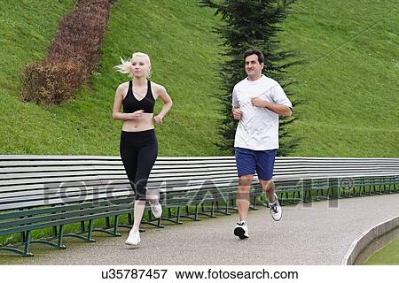 Man and woman running on pathway beside lake View Large Photo Image Stock Photo - Man and woman running on pathway beside lake. Fotosearch
