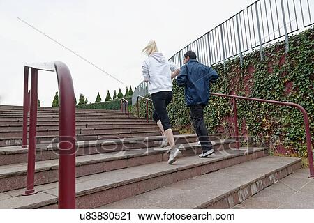 "Man and woman running up steps together, rear view" View Large Photo Image Stock Image - "Man and woman running up steps together, rear view". Fotosearch