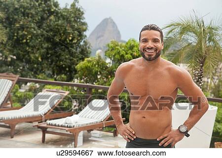 Stock Photo - "Man by poolside, Sugarloaf Mountain in background, RIo, Brazil". Fotosearch