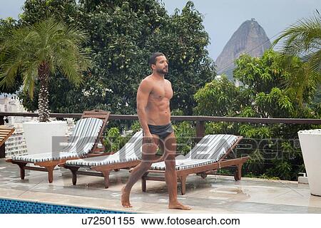Stock Photography - "Man by poolside, Sugarloaf Mountain in background, RIo, Brazil". Fotosearch