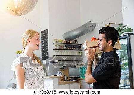 Stock Photo - Man delivering crate of vegetables to shopkeeper. Fotosearch
