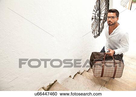 Man going up stairs with luggage View Large Photo Image Stock Image - Man going up stairs with luggage. Fotosearch