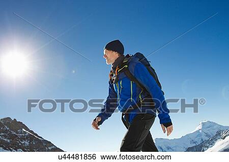 Stock Photograph - "Man hiking in snow covered mountains, Jungfrauchjoch, Grindelwald, Switzerland". Fotosearch