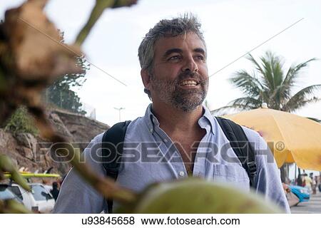 Stock Photo - "Man, palm trees in background". Fotosearch