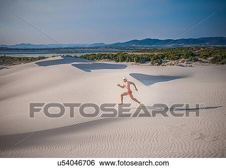 "Man running across sand, Cagliari, Sardinia, Italy" View Large Photo Image Stock Photograph - "Man running across sand, Cagliari, Sardinia, Italy". Fotosearch