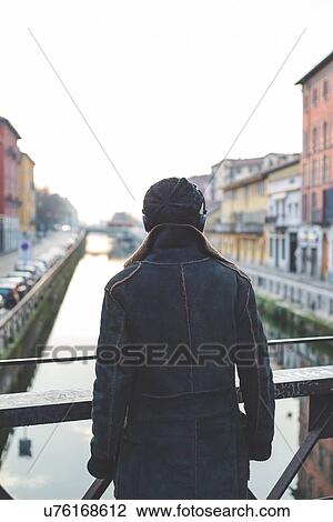 Stock Image - "Man standing by canal, Milan, Italy". Fotosearch
