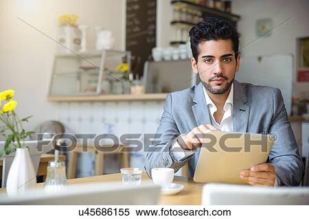 Man using digital tablet in cafe View Large Photo Image Stock Photography - Man using digital tablet in cafe. Fotosearch