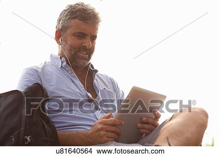 Man using digital tablet View Large Photo Image Picture - Man using digital tablet. Fotosearch