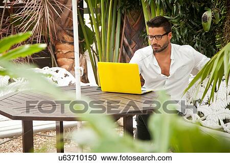 Man using laptop on patio View Large Photo Image Stock Image - Man using laptop on patio. Fotosearch