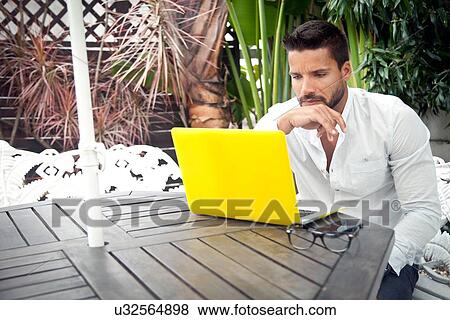 Man using laptop on patio View Large Photo Image Stock Photo - Man using laptop on patio. Fotosearch