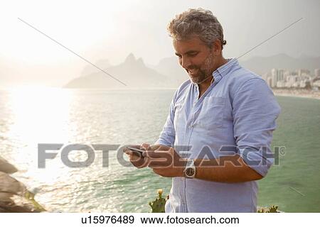 "Man using smartphone, Ipanema Beach, Rio de Janeiro, Brazil" View Large Photo Image Stock Photo - "Man using smartphone, Ipanema Beach, Rio de Janeiro, Brazil". Fotosearch